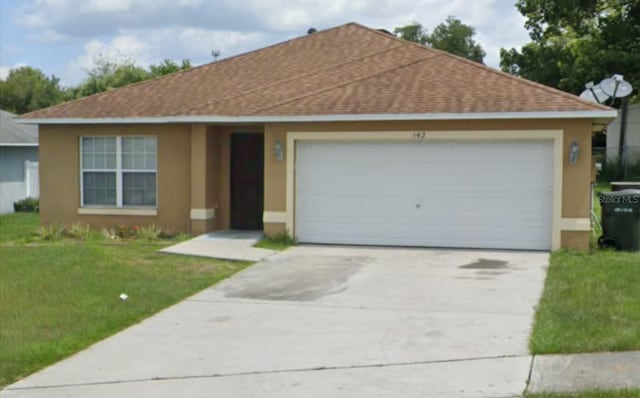 ranch-style home featuring a shingled roof, an attached garage, a front lawn, and stucco siding