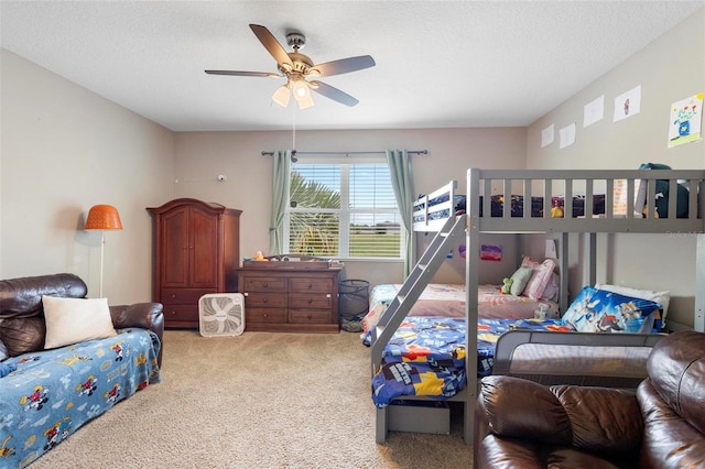 bedroom featuring a textured ceiling, a ceiling fan, and carpet flooring