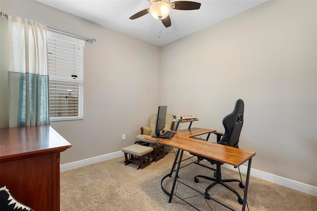 office area with baseboards, a ceiling fan, and light colored carpet