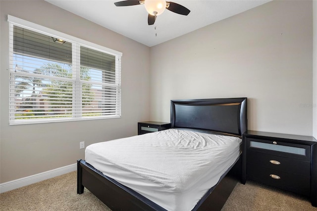 bedroom featuring ceiling fan, baseboards, and light colored carpet