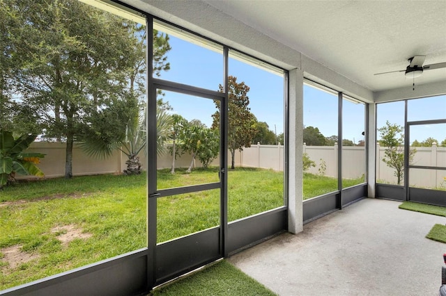 unfurnished sunroom with a ceiling fan