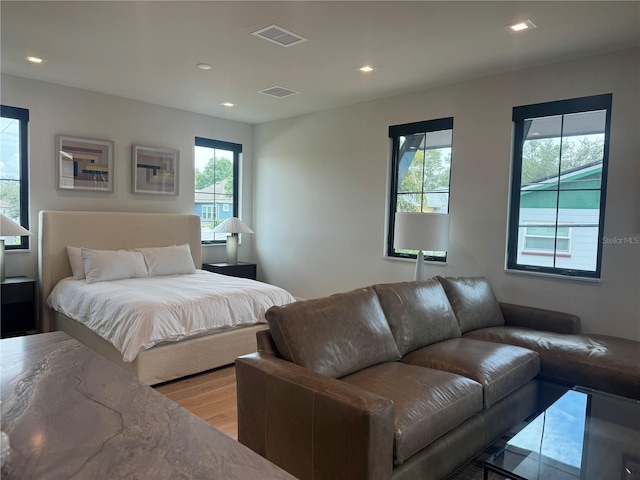 bedroom with light wood-style flooring, visible vents, and recessed lighting