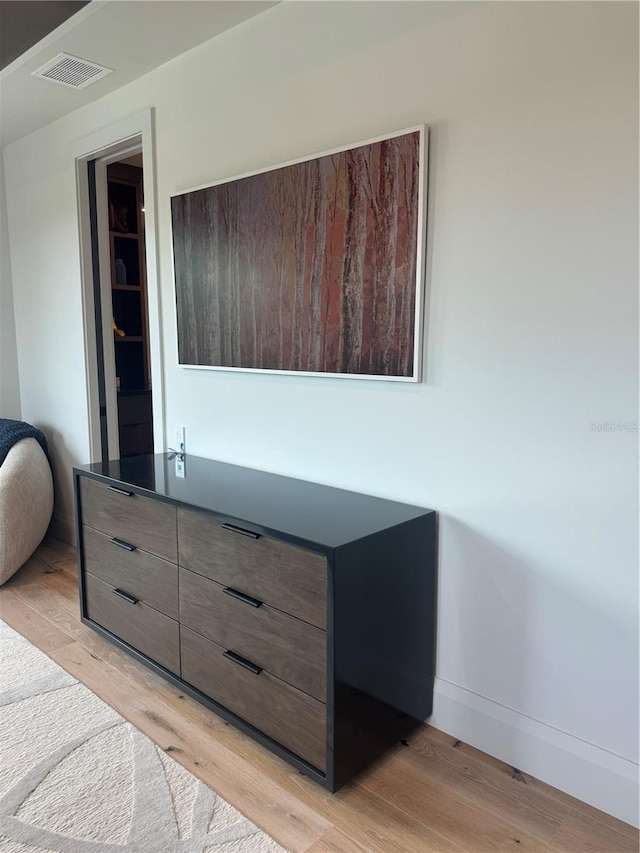 interior details with baseboards, visible vents, and wood finished floors