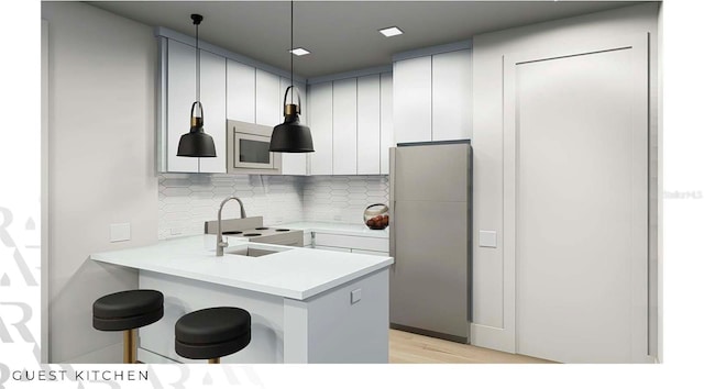 166 Hammock Preserve Loop, Winter Garden, FL 34787 - kitchen featuring freestanding refrigerator, stainless steel microwave, backsplash, a kitchen breakfast bar, and a peninsula