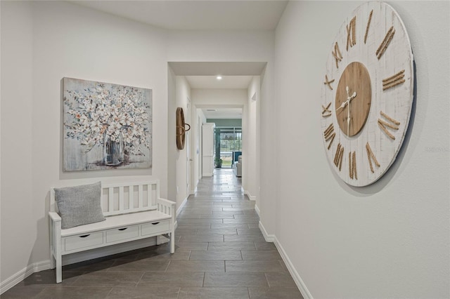 hallway with baseboards and wood finish floors