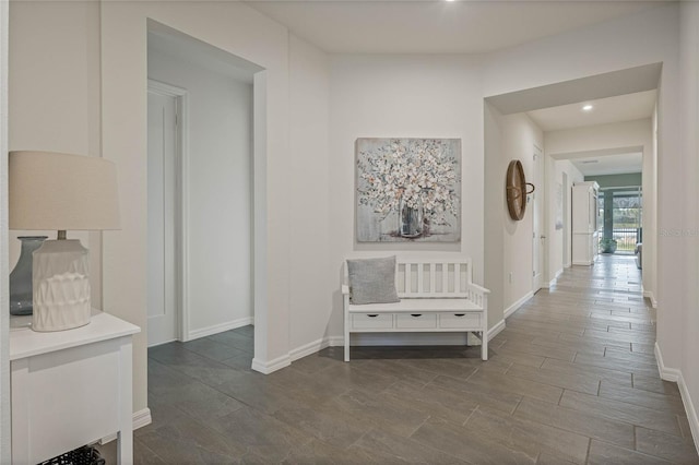 corridor with dark wood finished floors and baseboards