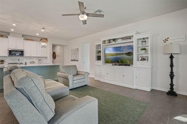 living room featuring ceiling fan, visible vents, baseboards, and recessed lighting