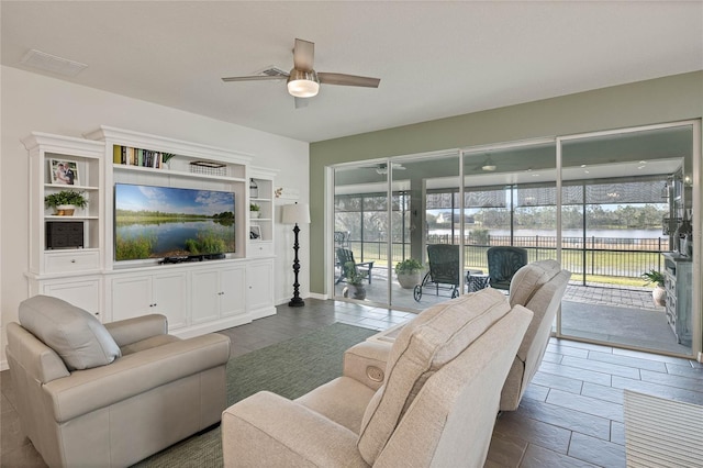 living room with ceiling fan and baseboards