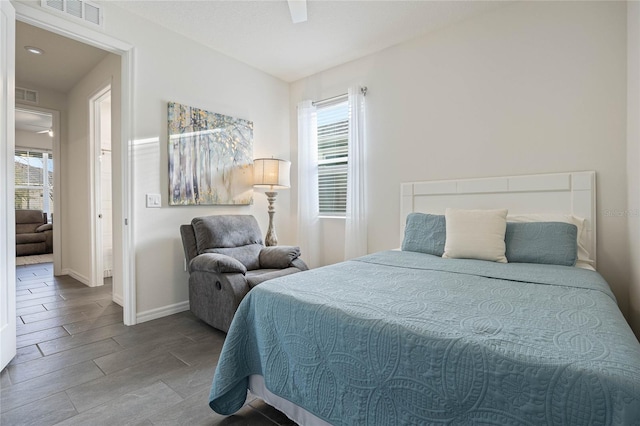 bedroom with wood finish floors, visible vents, ceiling fan, and baseboards