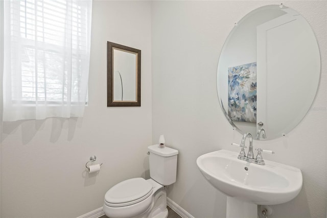 bathroom featuring a sink, toilet, and baseboards