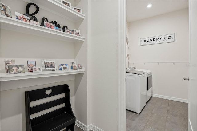 clothes washing area with laundry area, washing machine and dryer, and baseboards