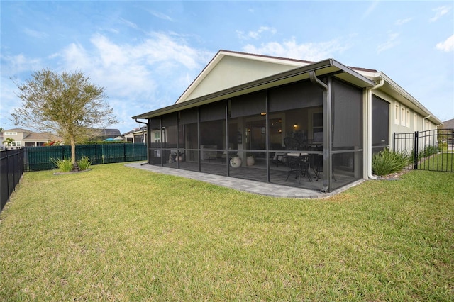 back of house with a patio, stucco siding, a lawn, a sunroom, and a fenced backyard