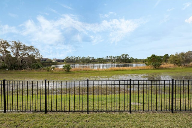 view of yard featuring a water view and fence