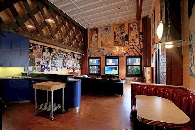 bar featuring a community bar, a sink, dark wood finished floors, and a towering ceiling