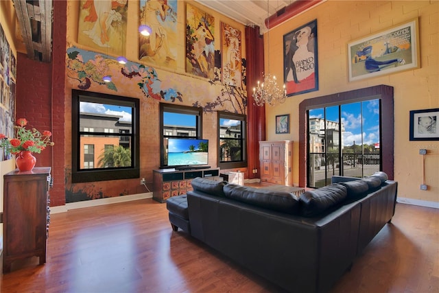 living area featuring a high ceiling, wood finished floors, and baseboards