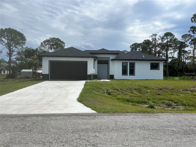 view of front facade with a front lawn, concrete driveway, and an attached garage