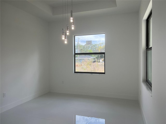 empty room with a tray ceiling and baseboards