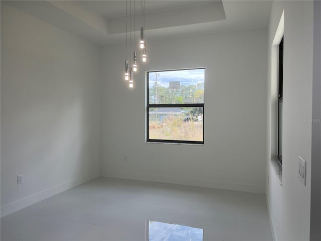 unfurnished room with a raised ceiling and baseboards