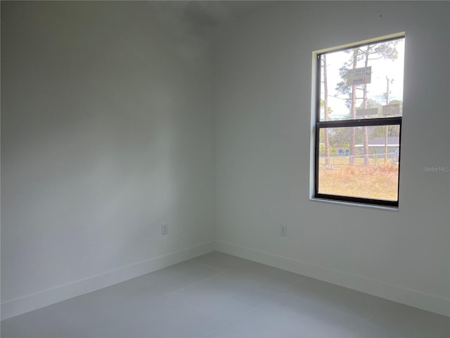 unfurnished room with baseboards