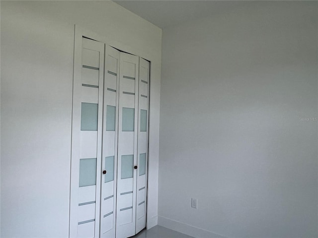 unfurnished bedroom with a closet and baseboards