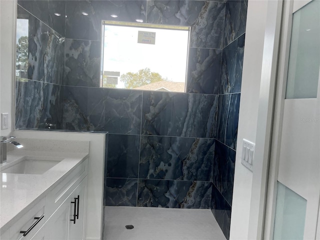 full bath with tiled shower and vanity