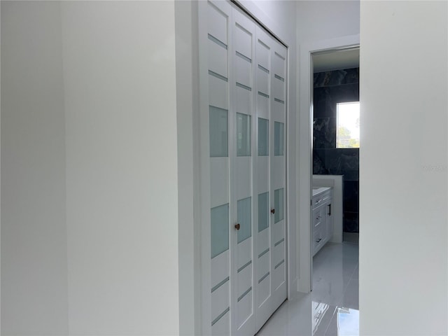 hallway featuring marble finish floor and tile walls