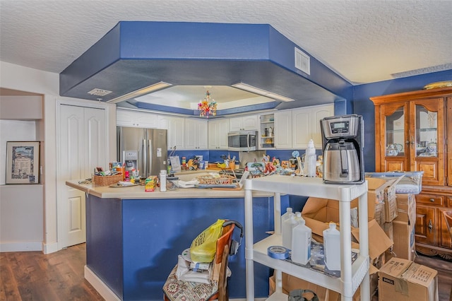 kitchen featuring visible vents, white cabinets, dark wood-style floors, stainless steel appliances, and light countertops