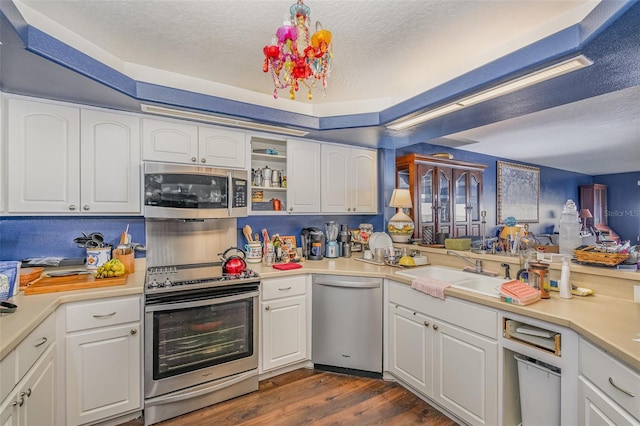 kitchen with a textured ceiling, white cabinetry, stainless steel appliances, and light countertops