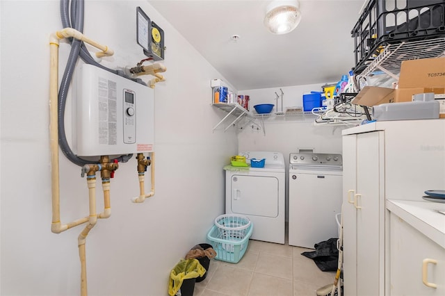 clothes washing area featuring water heater, laundry area, light tile patterned floors, and independent washer and dryer