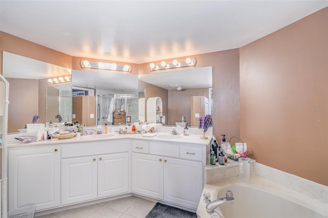 full bathroom with tile patterned flooring, a sink, a bath, and double vanity