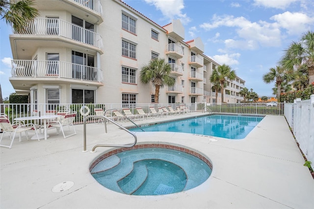 pool featuring a patio area, fence, and a community hot tub