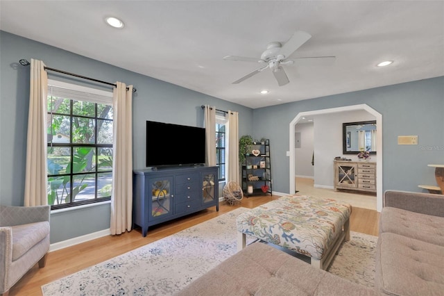 living room with arched walkways, baseboards, recessed lighting, and wood finished floors