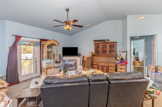 living area featuring carpet floors, ceiling fan, and vaulted ceiling