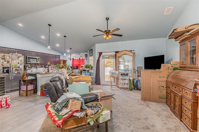 living area featuring vaulted ceiling, visible vents, and a ceiling fan