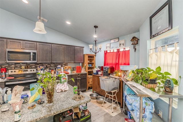 kitchen with dark brown cabinets, appliances with stainless steel finishes, and light stone countertops