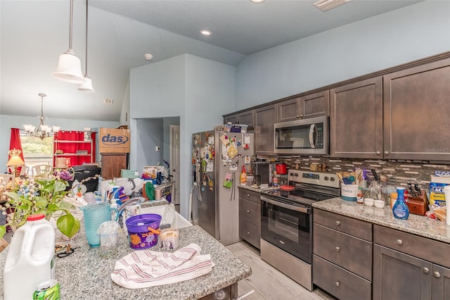 kitchen with stainless steel appliances, dark brown cabinetry, light wood finished floors, and light stone countertops