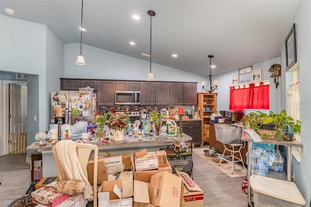 kitchen featuring stainless steel appliances, decorative light fixtures, dark brown cabinetry, and light wood-style flooring