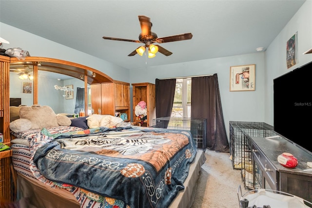 bedroom with arched walkways, light colored carpet, and ceiling fan