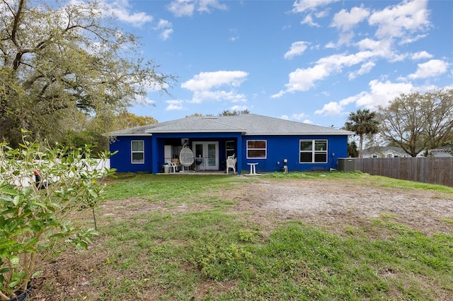 back of house with a lawn and fence