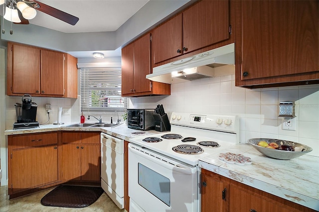 kitchen with white appliances, light countertops, a sink, and under cabinet range hood