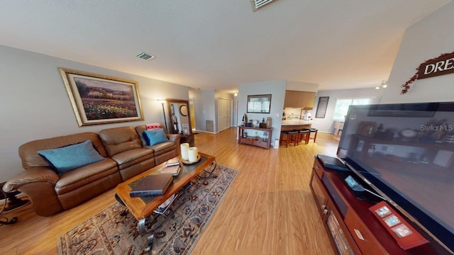 living area featuring visible vents and light wood-style floors