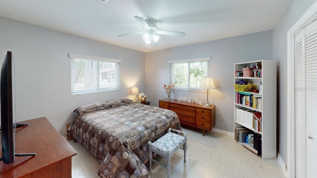 bedroom with a closet, ceiling fan, and baseboards