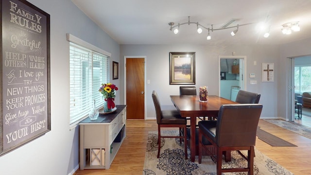 dining space featuring light wood-type flooring and baseboards