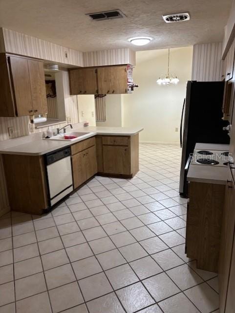 kitchen with a peninsula, brown cabinetry, light countertops, and dishwasher