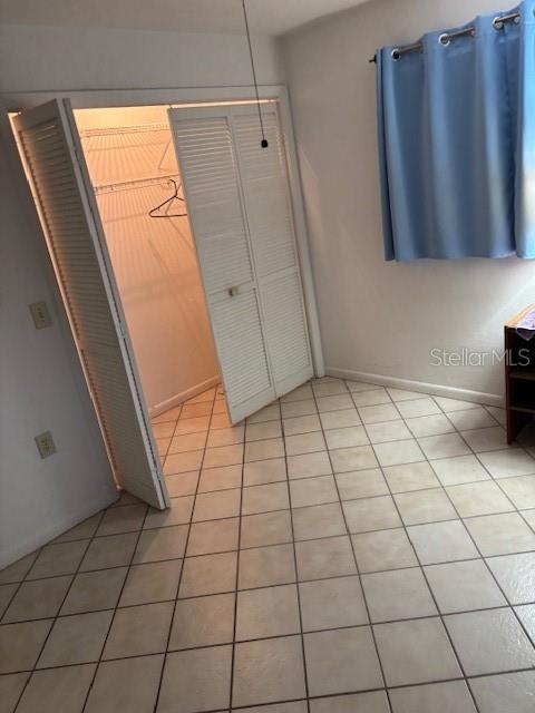 unfurnished bedroom with a closet and light tile patterned floors