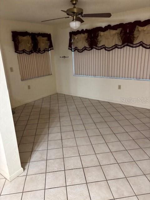 spare room with ceiling fan and light tile patterned floors