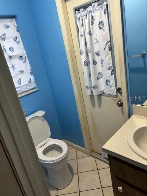 bathroom with vanity, tile patterned flooring, and toilet