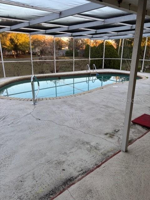 outdoor pool with a lanai and a patio