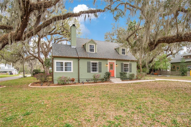 cape cod house with a shingled roof, crawl space, a chimney, and a front lawn