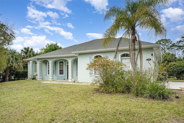 ranch-style home with a front yard and stucco siding